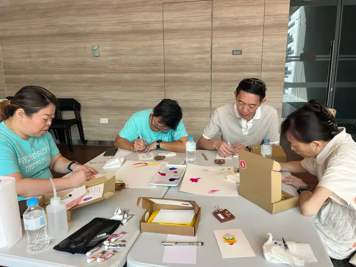 A bright room with a handful of people around one table